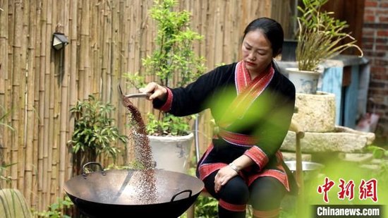 4月3日,谭芝祯在炒米做鲊肉。刘卓 摄