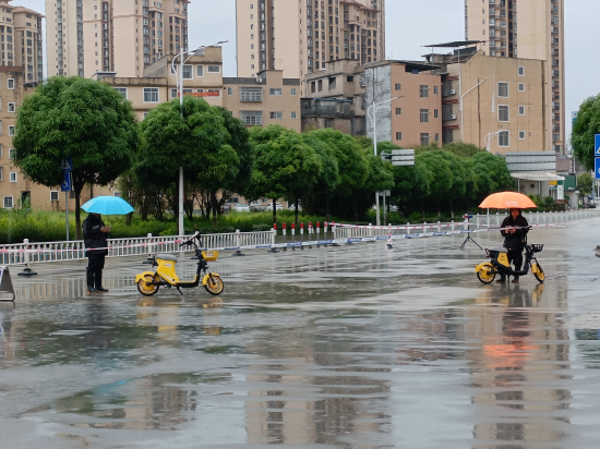 图为 城管人员在涉水路段值守封路,避免市民淌水过街